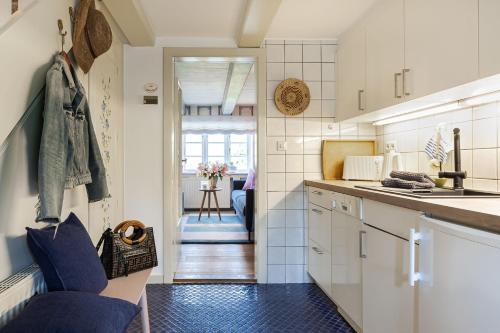 a kitchen with white cabinets and a blue tile floor at Im Lütten in Braderup