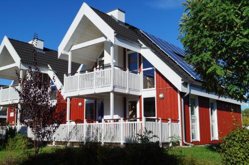 a red and white house with a white porch at Marinapark Scharmützelsee in Wendisch Rietz