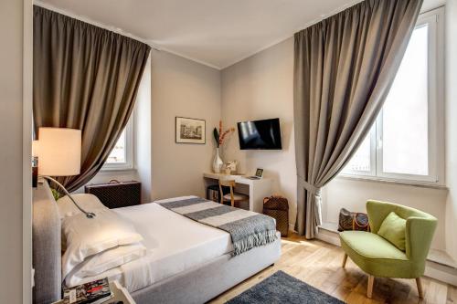 a bedroom with a bed and a green chair at The Club Navona in Rome