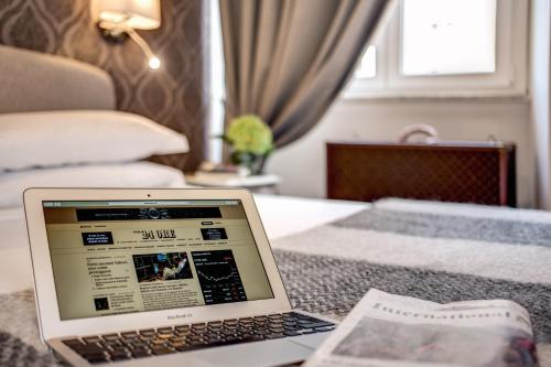 a laptop computer sitting on top of a bed at The Club Navona in Rome