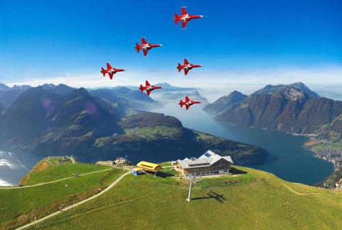 a group of red planes flying in formation over a mountain at Wohnung mit Herz in Schwyz