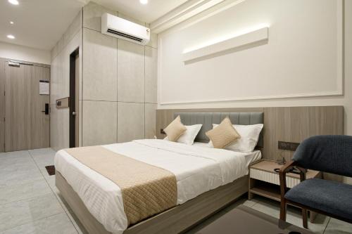 a bedroom with a large bed and a chair at The Grand Platinum Hotel in Ahmedabad