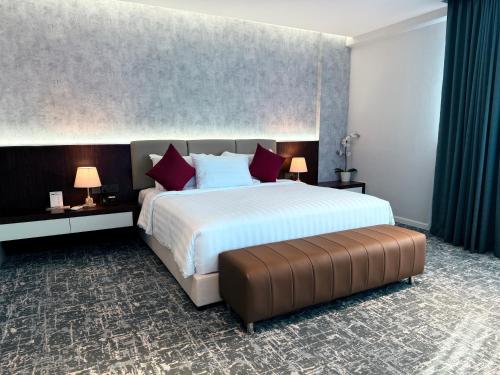 a hotel room with a large bed with red pillows at MITC Hotel in Melaka