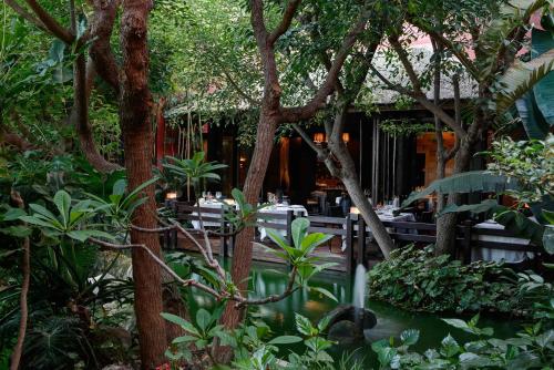 a restaurant with tables and trees and a pond at Asia Gardens Hotel & Thai Spa, a Royal Hideaway Hotel in Finestrat