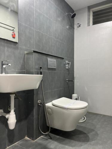 a bathroom with a white toilet and a sink at Vijey Hotels in Tiruchirappalli