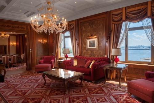 a living room with red furniture and a chandelier at Fairmont Grand Hotel Kyiv in Kyiv