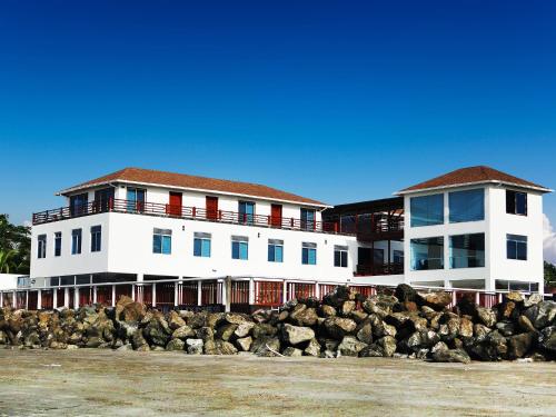 a large white building behind a pile of rocks at La Bocana de Quiximies Hotel in Cojimíes