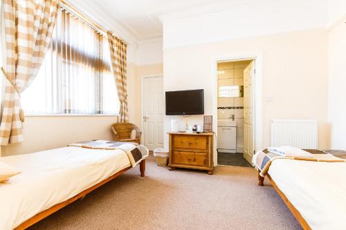 1 dormitorio con 2 camas y TV en The Old Crown Inn en Sheffield