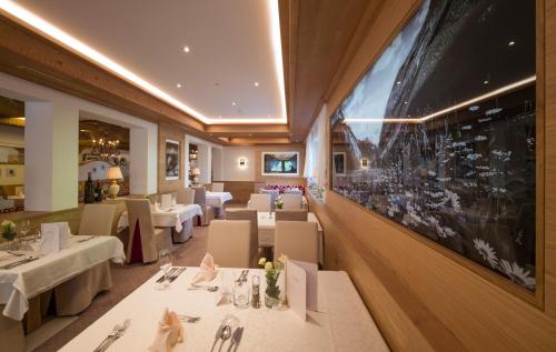 a restaurant with tables and chairs and a large picture on the wall at Hotel Neue Post in Hippach