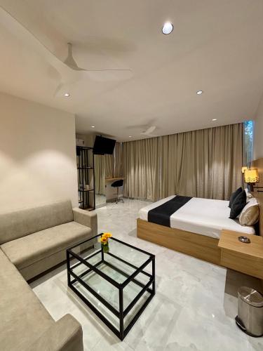 a bedroom with a bed and a couch and a table at The Hyde Park Inn in Bilāspur