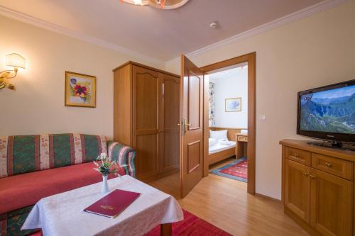 a living room with a couch and a television at Hotel Neue Post in Hippach