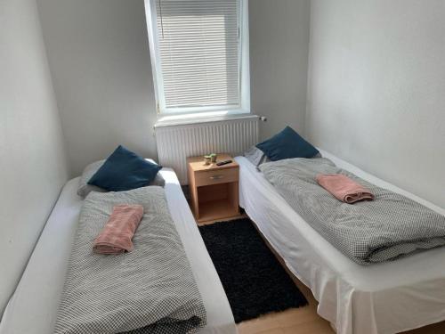 two beds in a small room with a window at Padborg Inn - Simple Rooms & Modern Apartments in Padborg