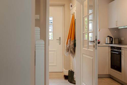 a kitchen with a door open to a kitchen with a stove at Haus Möhre in Tinnum