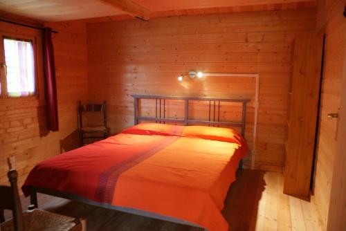 een slaapkamer met een bed in een blokhut bij Chalets Sybelles in Saint-Sorlin-dʼArves