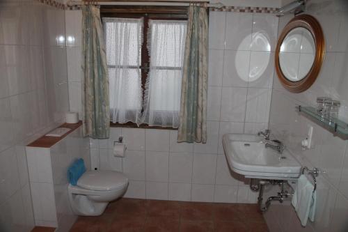 a bathroom with a toilet and a sink at Wirtshaus und Pension Hocheck in Ramsau
