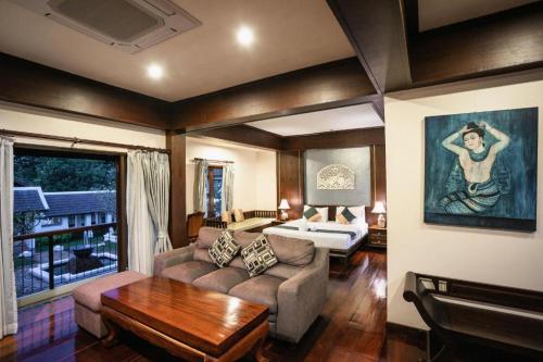 een woonkamer met een bank en een tafel bij Wiangkaew Hotel in Ban Fai Kaeo