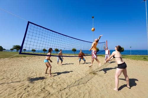 a group of people playing volleyball on the beach at Camping Park Umag Mobile Homes in Umag