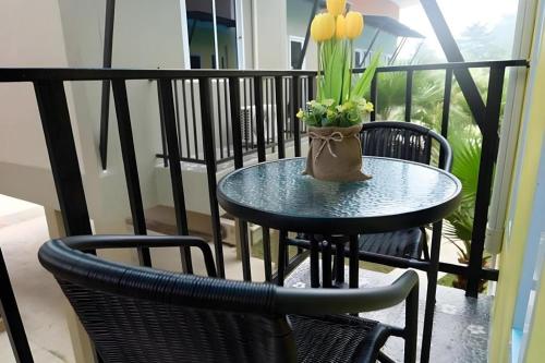 een kleine tafel met een vaas met bloemen op een balkon bij Satun Boutique Resort in Satun