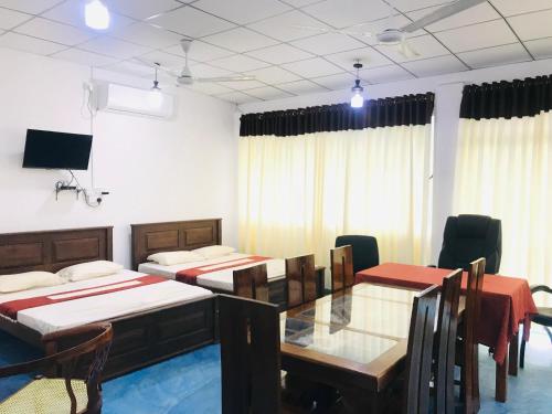 una stanza con due tavoli e sedie e un tavolo da pranzo di Elliot Nature Resort a Galle