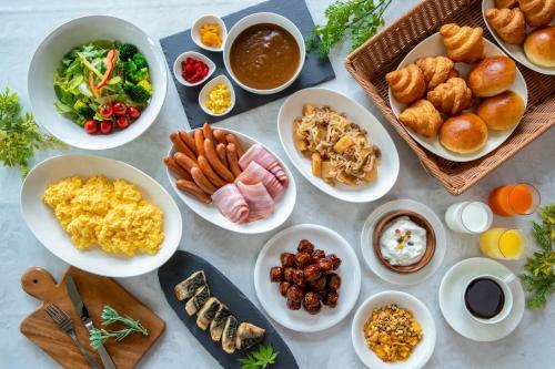 a table full of plates of food with different foods at Fujisan Station Hotel in Fujiyoshida