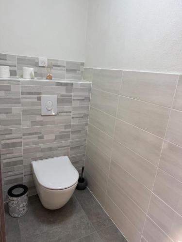 a bathroom with a white toilet in a room at The Nest - cosy chalet for two in Jarjayes