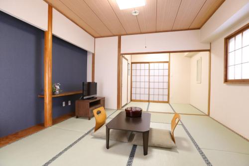 a living room with a table and chairs at ニュースターホテル山中湖 in Yamanakako