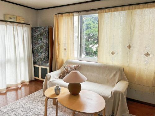 a living room with a couch and a table with a lamp at Hi Song Villa in Otaru