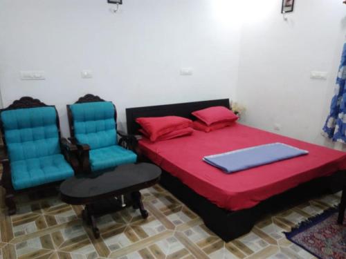 a bedroom with a bed and two chairs at Skyfall Villa in Chillithodu