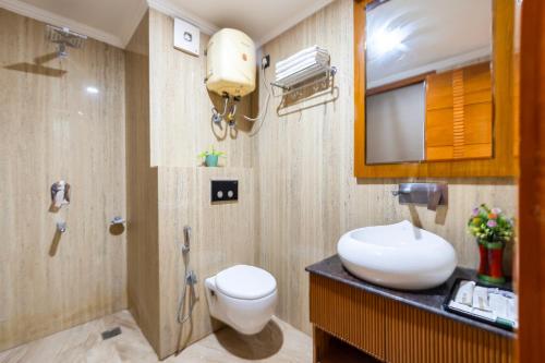 a bathroom with a toilet and a sink and a mirror at The Global Hotel by Platinum I 100m Medanta Hospital I Sector-38 I Gurgaon in Gurgaon