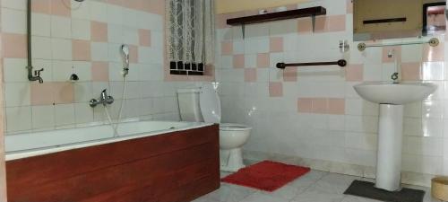 een badkamer met een bad, een toilet en een wastafel bij Maison d'hôtes Villa Mont du Pèlerin à Toamasina Madagascar in Toamasina