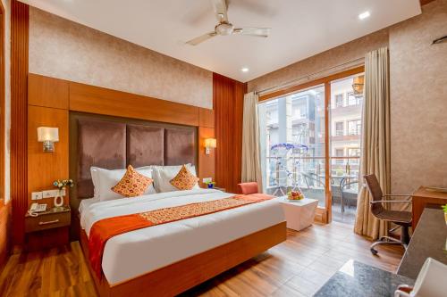 a hotel room with a large bed and a balcony at The Global Hotel by Platinum I 100m Medanta Hospital I Sector-38 I Gurgaon in Gurgaon