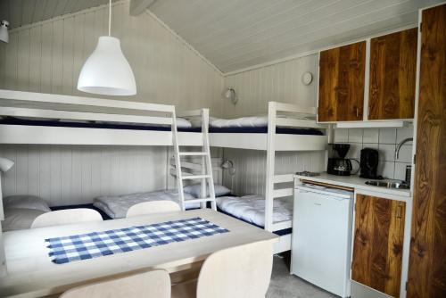 a room with bunk beds with a table and chairs at Gullbrannagården in Halmstad