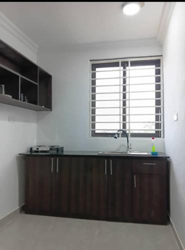 eine Küche mit Spüle und Fenster in der Unterkunft Meg place in Ofankor