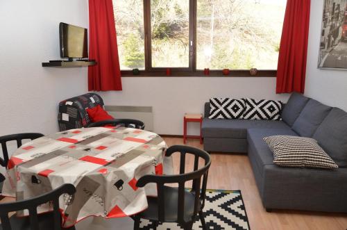 ein Wohnzimmer mit einem Tisch und einem Sofa in der Unterkunft Appartement Flaine Forêt in Flaine