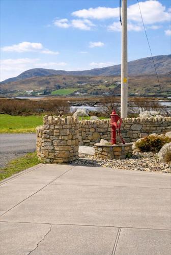 a red fire hydrant next to a stone wall at Sonnys Rest in Ardara