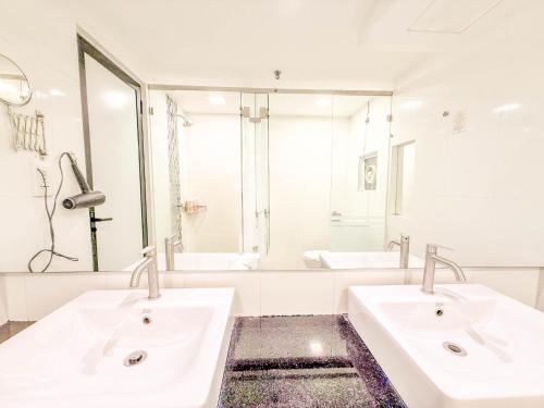een badkamer met twee wastafels en een grote spiegel bij Modern Seaview 2BR Duplex High Floor Heart of George Town 73A in George Town