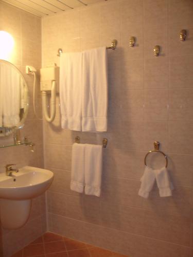 a bathroom with white towels and a sink at Hotel Klisura in Sunny Beach