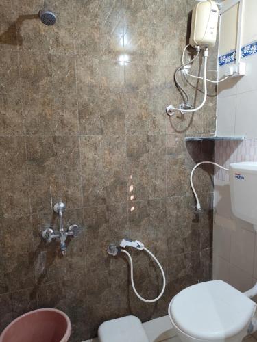 a bathroom with a shower with a toilet at Dongre's Farm, Malshej Ghat in Junnar