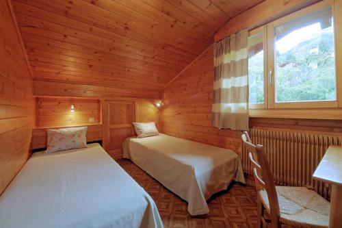ヴェルビエにあるDrelo 3の木造キャビン内のベッドルーム1室(ベッド2台付)