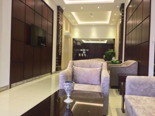 ein Wohnzimmer mit 2 Stühlen und einem Tisch in der Unterkunft Raha Suites in Dammam