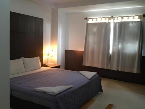 万象Senesouk Hotel的一间带大床的卧室，带窗户