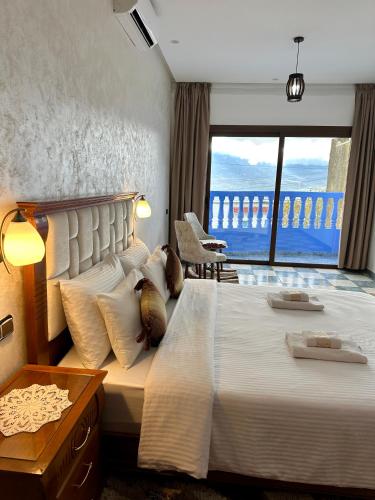 a bedroom with a large bed with a large window at IDGA appartement with panoramic view in Chefchaouen