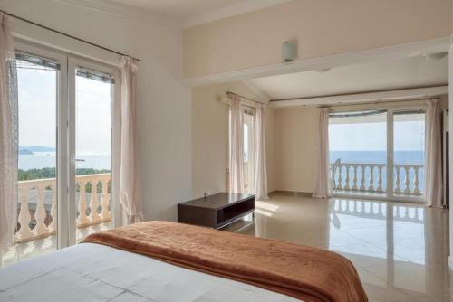 een witte slaapkamer met een bed en een balkon bij Apartman -PANORAMA LUX in Sutomore