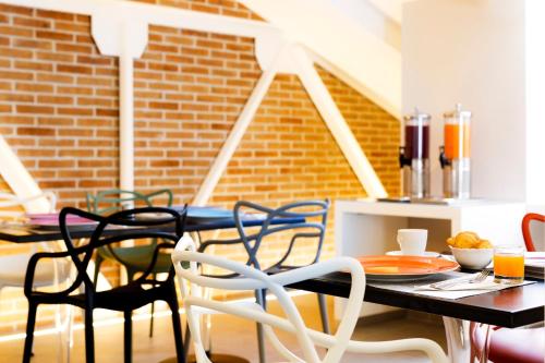 a table and chairs in a room with a brick wall at Best Western Plus Royal Superga Hotel in Cuneo