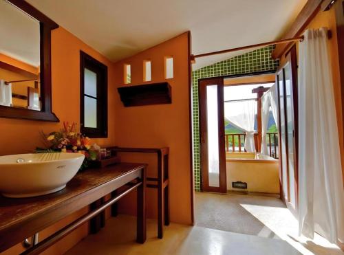 ein Badezimmer mit einem Waschbecken und ein Badezimmer mit einem Fenster in der Unterkunft Pai Hotsprings Spa Resort in Ban Tha Pai