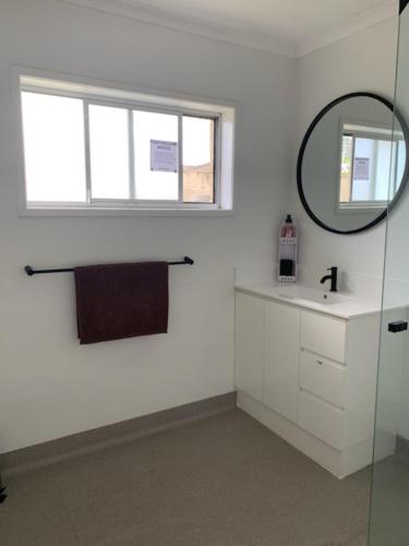 een badkamer met een wastafel en een spiegel bij Gold Coast Rooms in Gold Coast