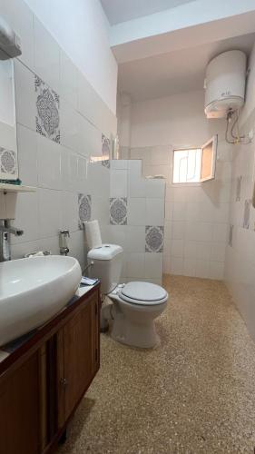 a bathroom with a white toilet and a sink at Villa mit Pool in Mbour in Mbour