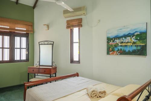 a bedroom with a bed and a dresser and a mirror at Self Cate Luxury Apartments in Kandy