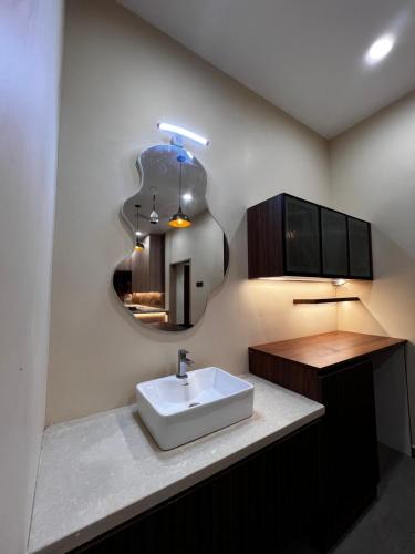 een badkamer met een wastafel en een spiegel bij Tamizh Agam in Ramanathapuram