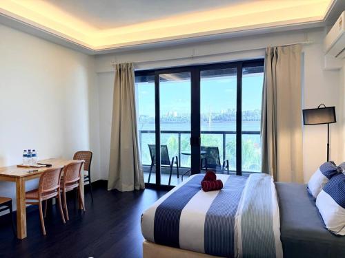 a bedroom with a bed and a dining room with a table at R&F Princess Cove JB Apartment Suites By SC Homestay in Johor Bahru